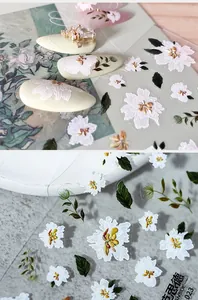 Detail of 3D floral nail stickers with white flowers, green leaves and pearl accents