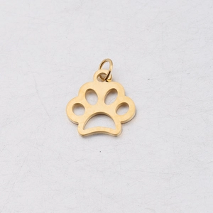 Détail macro du pendentif patte de chien évidé doré avec petit anneau de jonction DIY