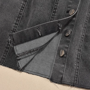 Détails des boutons métalliques et de l'ourlet effiloché sur robe en jean gris foncé