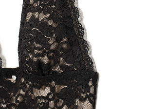 Détail du motif floral en dentelle noire et texture en maille de la robe dos nu