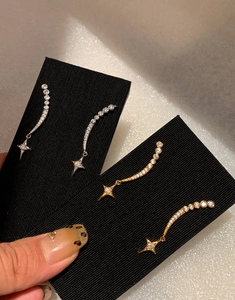 Detailed view of star pendant earrings featuring gold and silver zircon tassels