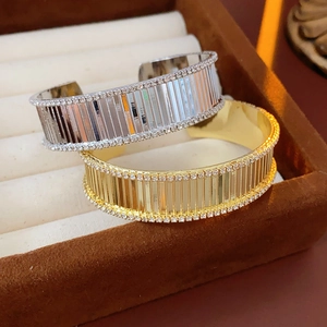 Détails macro de bracelets ouverts dorés et argentés avec rainures et bords en strass