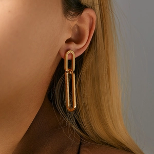 Minimalist double link gold hoop earrings with matte finish worn by model in profile view