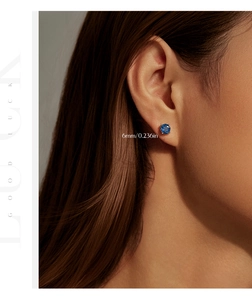 Close-up of 6mm royal blue rose cut stud earrings on ear with elegant silver four-prong setting