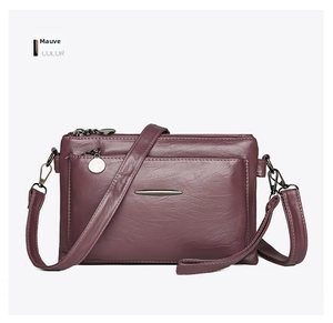 Detail of multi-layer zipper crossbody bag in dusty rose pebbled faux leather