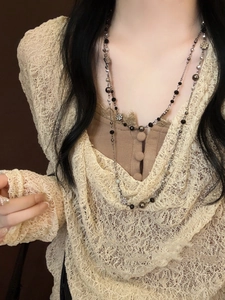 Detail of double-layer beaded necklace featuring vintage metal flowers and crystal beads