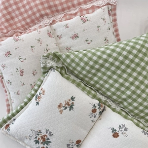 Détail de poches de rangement en tissu à carreaux et fleurs avec bordure dentelle