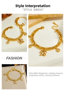 Close-up of gold-plated double-layer bracelet with butterfly and teardrop stone charms