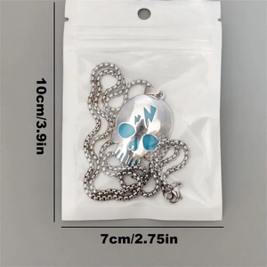Detailed view of silver skull necklace with blue lightning icon in clear packaging bag