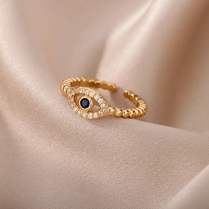 Macro shot of evil eye ring with blue stone and twisted band on silk fabric