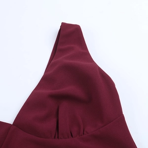 Detail of elegant burgundy dress featuring a pleated V-neckline and high-quality woven fabric