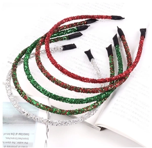 Detail of glittery Christmas headbands in red, green, and silver on a magazine backdrop