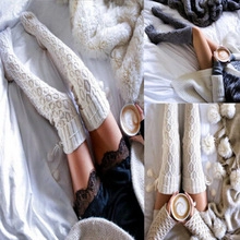 Close-up of white and dark grey knitted over-the-knee socks showing warm cozy texture