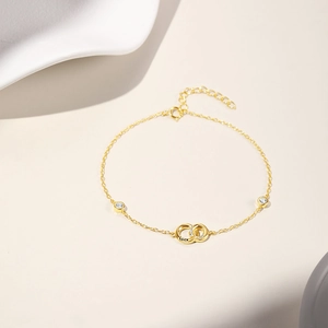 Detail of interlocking golden rings with LUCK engraving and sparkling pavé crystals