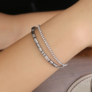 Close-up of double-layer silver bracelet featuring a tennis chain and morse code bar design