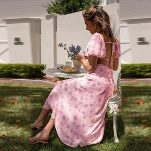 Detailed view of pink floral dress featuring puff sleeves and backless lace-up design