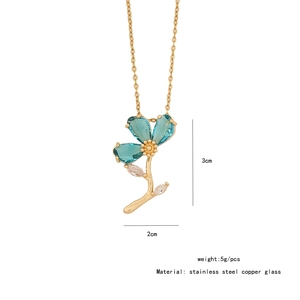 Detail shot of a gold flower pendant with blue glass petals and crystal accents