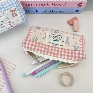 Macro shot of large capacity checkered canvas pencil case with cute ribbon and zipper detail