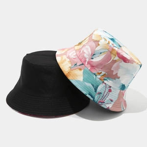 Detail view of double-sided bucket hat with solid black and colorful floral pattern