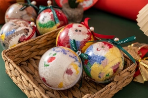 Close-up of festive Christmas coral fleece socks in decorative ball gift packaging
