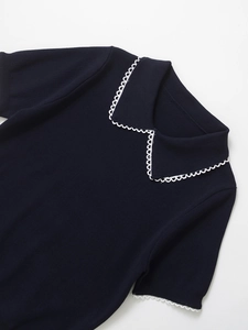 Detail of navy knit top featuring white scalloped edges on collar and short sleeves