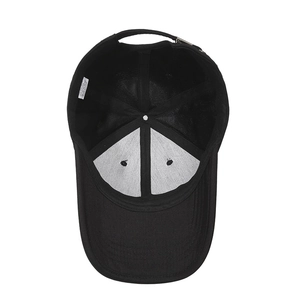 Interior view of a minimalist black cotton baseball cap showing lining and metal button detail