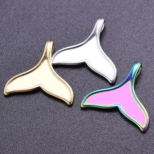Detailed view of whale tail charms in gold, silver and rainbow plated stainless steel