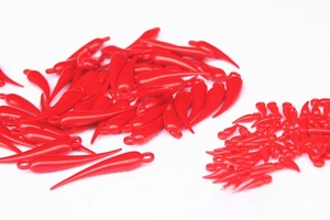 Close-up of shiny red plastic chili pendants in two sizes for festive DIY decorations