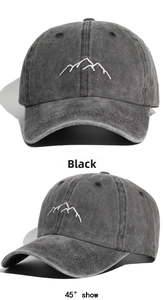Detail view of washed cotton baseball cap with white mountain embroidery on front