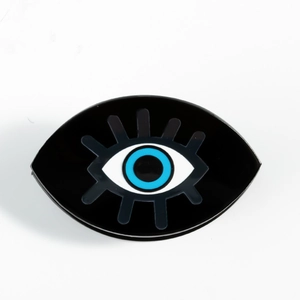 Detail of black oval hair claw clip with blue evil eye pattern for elegant hairstyling