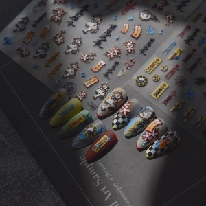 Close-up of Japanese-style embossed nail stickers with calligraphy and charm patterns