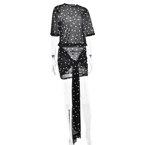 Detail view of black polka dot mesh two-piece set with a mini skirt and tie-waist ribbon