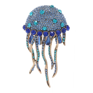 Blue rhinestone jellyfish brooch with gold tassels and teardrop gems on white background