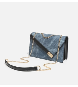 Detail view of denim texture small square bag with golden chain and black leather trim