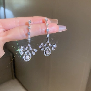 Sparkling silver drop earrings with waterdrop zircon and fringe details shown on hand