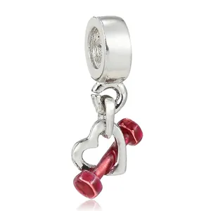Detail of silver heart charm and red enamel dumbbell pendant for DIY bracelets