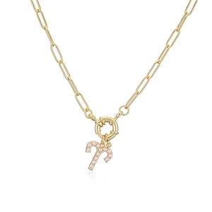Detail of gold paperclip chain necklace with a pearl-inlaid Aries zodiac pendant