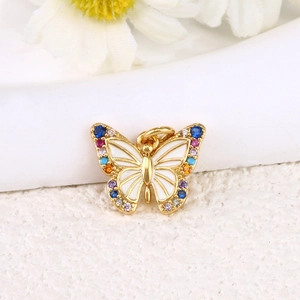 Macro view of gold plated butterfly pendant with white enamel and colorful crystals