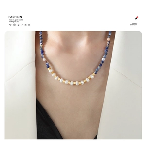 Detail of natural blue stones and freshwater pearls on a layered beaded necklace