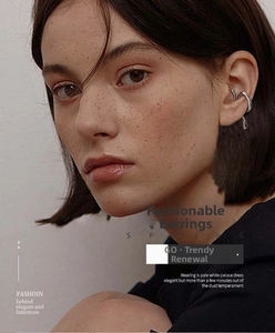 Close-up of irregular silver ear cuff with minimalist streamlined design on model