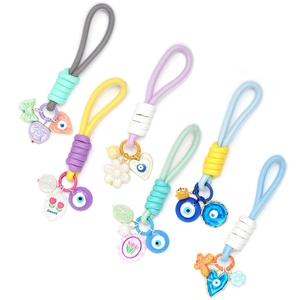 Détail de porte-clés tressés mauvais œil avec breloques colorées et anneaux en métal