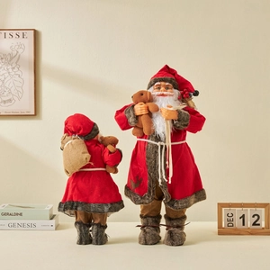 Classic red Santa Claus doll holding teddy bear and burlap gift bag for window display
