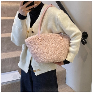 Gros plan d'un sac à main en peluche rose clair avec de fines anses élégantes