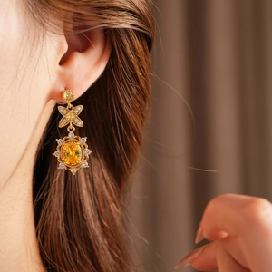 Details von Vintage-Goldohrringen mit gelben Kristallen und Zirkonia-Schleifendesign
