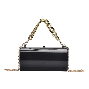 Elegant black cylindrical acrylic evening bag with gold chain handle and crossbody strap