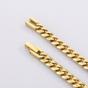 Macro shot of polished gold Cuban link chain showing square clasp and fine metal texture