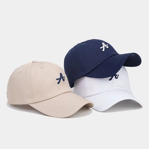 Detailed embroidery of letter A on twill baseball caps in khaki, navy, and white