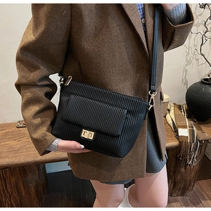 Chic black pleated shoulder bag with gold hardware shown in a cozy autumn lifestyle setting