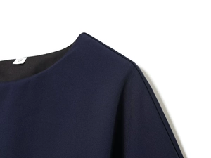 Détail de la couture plissée de l'épaule et de la texture du tissu sur une robe midi bleu foncé