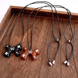 Vintage bow and star pendant necklace with wood texture on a dark brown wooden tray